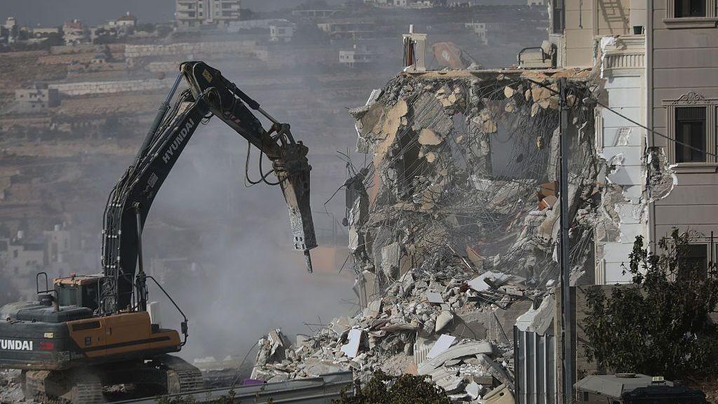 Israeli heavy military bulldozers operating near Palestinian buildings in Hebron following the shooting attack
