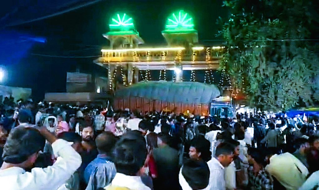 Emergency personnel and police officers conducting rescue operations near the damaged entrance wall of Sheetla Mata Temple in Gwalior
