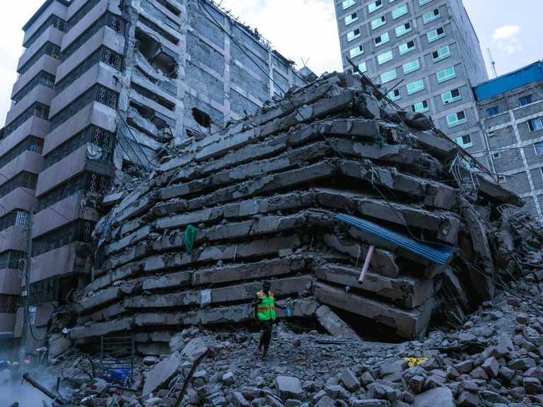 Rescue workers and heavy equipment searching through rubble after a building collapse in Eastleigh, Nairobi