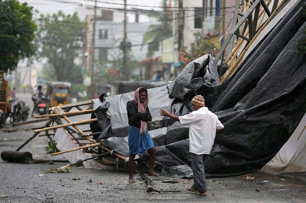 NDRF personnel evacuating coastal residents through flooded streets during Severe Cyclone Arnab landfall