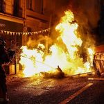 French riot police marching through tear gas smoke during protests in Paris