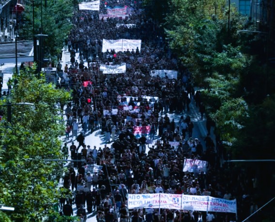 Greek teachers and university students holding banners during a demonstration outside Parliament on Syntagma Square in Athens