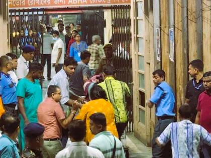 Disaster management personnel and Kolkata Police surrounding the closed exit gate of Chorbagan Durga Puja pandal following a deadly stampede