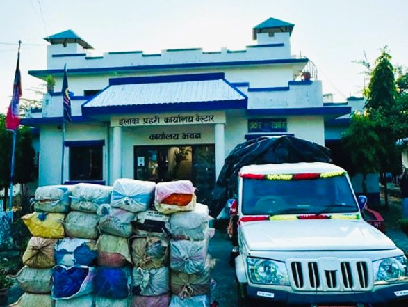 Udayapur police officers standing beside seized sacks of marijuana and an impounded Bolero pickup truck