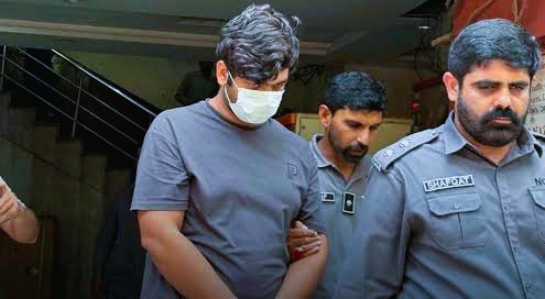 National Cyber Crime Investigation Agency officers standing beside suspect Faheem Akram in Khanewal, Pakistan following his arrest