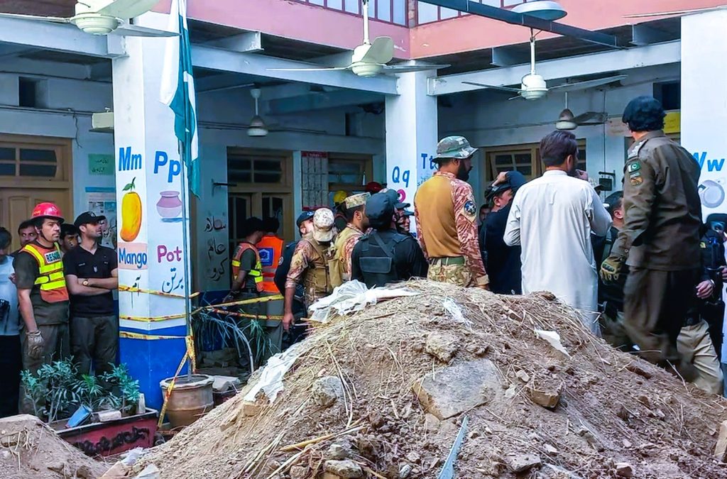 Rescue 1122 personnel and volunteers searching through concrete rubble following a school roof collapse in Peshawar, Pakistan