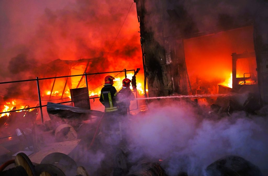 Emergency responders extinguishing fires at a residential building damaged by a missile strike in Kyiv